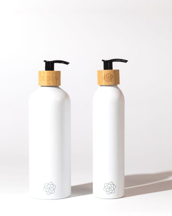 Refillable bathroom dispensers white matte with bamboo pump for minimalist bathroom for sustainable beauty products.