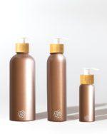 Refillable bathroom dispensers metallic rosegold with bamboo pump for minimalist bathroom and clean beauty.