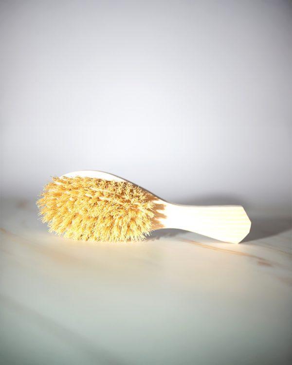 Natural Hair Brush, a biodegradable, artisan-crafted tool made from pine wood and natural sisal bristles.